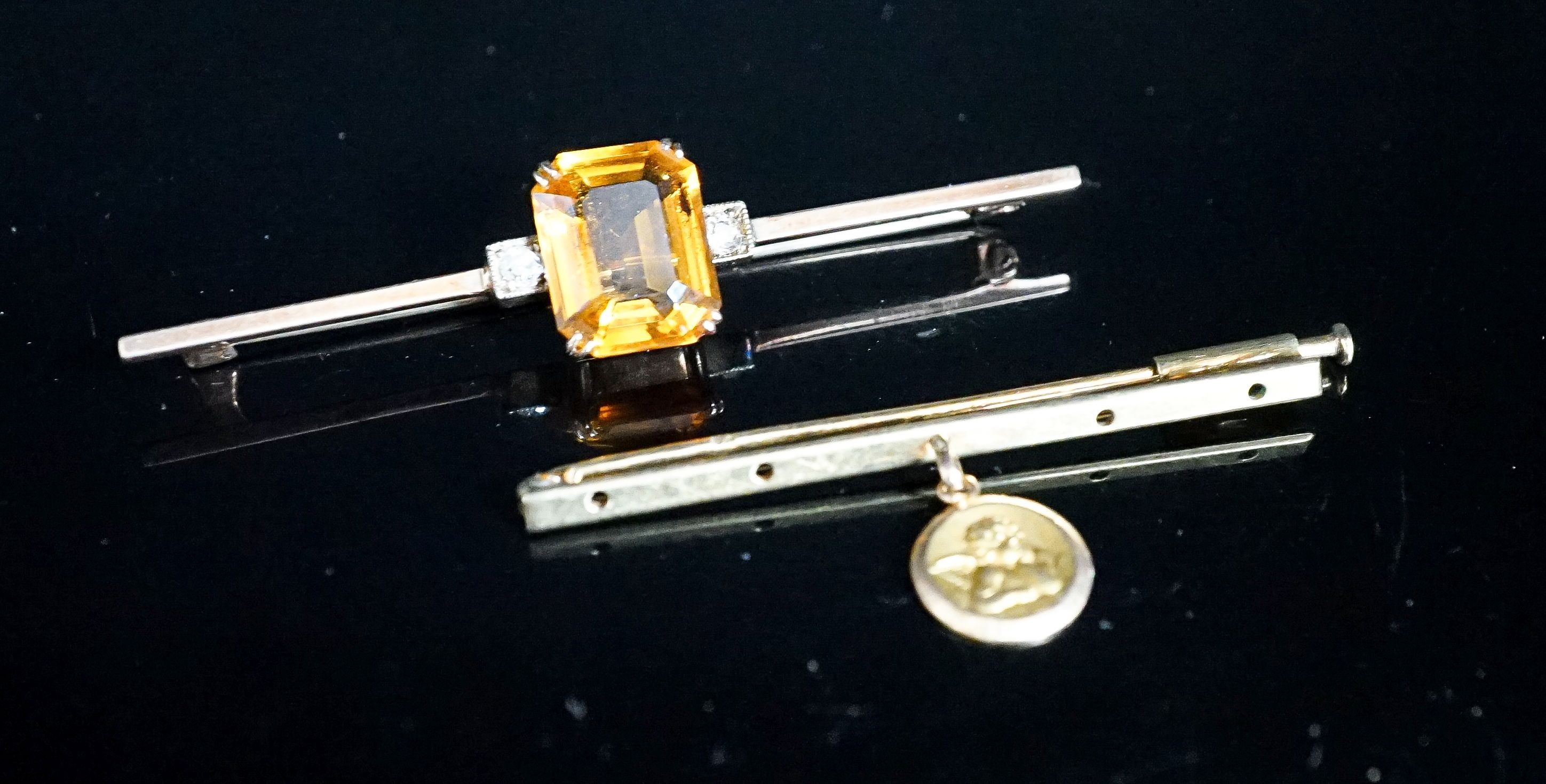 A yellow metal, single stone citrine and two stone diamond set bar brooch, 56mm and one other with cherub pendant charm, gross 6.3 grams.